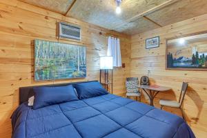 a bedroom with a blue bed in a wooden room at House & Tiny Cabin! Multi-Acre East TN Property in Englewood