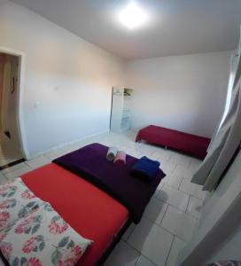 a small bedroom with a bed and a red blanket at Pousada Familiar 10 in Rio do Sul