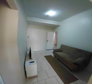 a living room with a couch and a tv in it at Pousada Familiar 10 in Rio do Sul