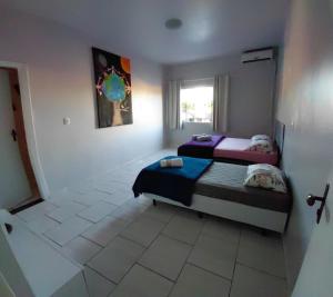 a bedroom with two beds and a window at Pousada Familiar 10 in Rio do Sul +2 photos