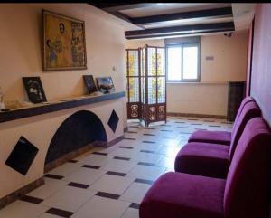 ein Wohnzimmer mit lila Sesseln und einem Kamin in der Unterkunft Student House in Madaba