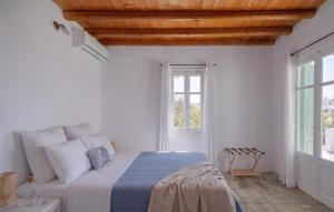 a bedroom with a bed with white walls and a wooden ceiling at Oneiro Serifos House in Serifos Chora