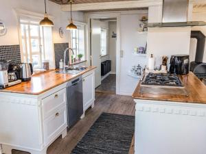 a kitchen with white cabinets and a stove top oven at 5 person holiday home in Øster Assels-By Traum in Øster Assels