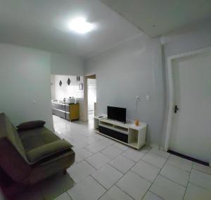 a living room with a couch and a laptop on a table at Pousada Familiar 10 in Rio do Sul