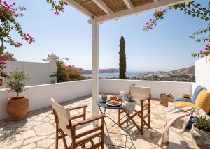 a patio with a table and chairs on a balcony at Oneiro Serifos House in Serifos Chora