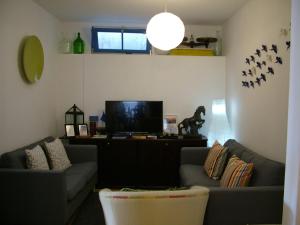 a living room with two couches and a flat screen tv at Casa dos Pedro´s in Vila Nova