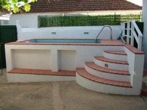 a bench with steps leading to a swimming pool at Casa dos Pedro´s in Vila Nova