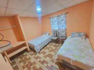 a small room with two beds and a window at Hostal la Majada la Vida es Bella in San José La Majada