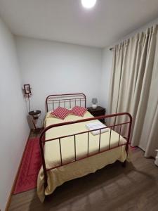 a bedroom with a bed and a window with curtains at RECANTO da VONINHA in Castelo de Paiva
