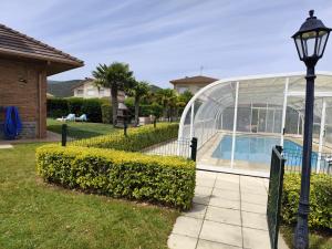 a glass house with a swimming pool and a street light at San Isidro in Villarcayo