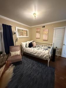 a bedroom with a bed and a chair at The Haven at Mariama House in Upper Marlboro