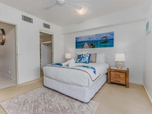a bedroom with a white bed and a table at Drift North Beachfront Apartments - Private Apartments in Kingscliff +63 photos