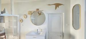 a bathroom with a sink and two mirrors on the wall at Chez Mary in Larzicourt
