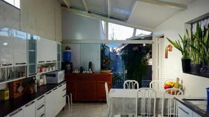 a kitchen with white cabinets and a table and chairs at Pousada Canto das Samambaias in Capitólio
