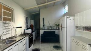 a kitchen with a white refrigerator and a blue chair at Pousada Canto das Samambaias in Capitólio