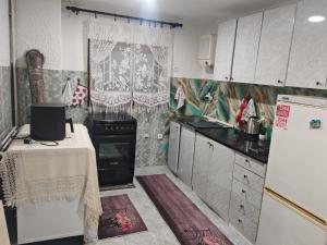 a kitchen with a refrigerator and a table in it at Apartman Darija in Vrnjci