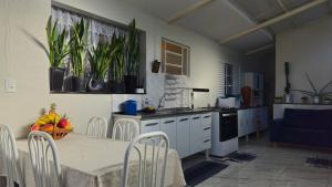 a kitchen with a table and some plants on the wall at Pousada Canto das Samambaias in Capitólio