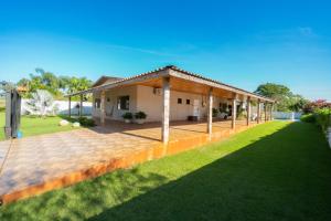 a house with a large patio in a yard at Casa de Campo Mimosa Flor Refugio Exclusivo Proximo Cataratas e Aeroporto IGU Piscina Privativa 12 Hóspedes in Foz do Iguaçu