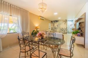 a dining room with a glass table and chairs at Casa de Campo Mimosa Flor Refugio Exclusivo Proximo Cataratas e Aeroporto IGU Piscina Privativa 12 Hóspedes in Foz do Iguaçu