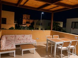 a patio with a couch and a table and chairs at Villa Favignana in Favignana