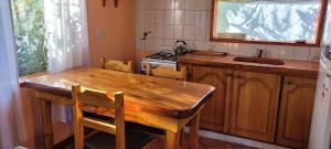 a kitchen with a wooden table and a sink at Cabañas Lago Guillelmo in San Carlos de Bariloche +19 photos