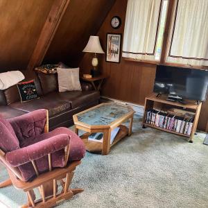 a living room with a couch and a coffee table at Adorable Aframe in the White Mountains in Conway