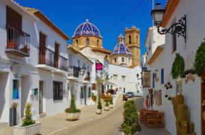 a street in a town with white buildings and blue domes at TAJ house center Altea #C in Altea