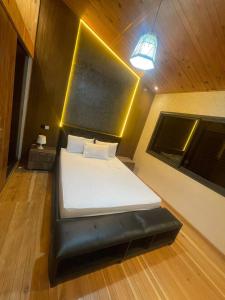 a bedroom with a bed with a black leather seat at Villa Moderne avec Piscine Privée in Imouzzer du Kandar +20 photos