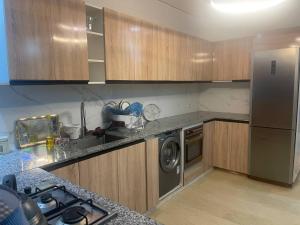a kitchen with wooden cabinets and a stainless steel refrigerator at Villa Moderne avec Piscine Privée in Imouzzer du Kandar
