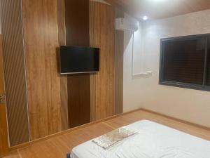 a small room with a bed and a flat screen tv at Villa Moderne avec Piscine Privée in Imouzzer du Kandar