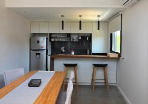 a kitchen with a wooden table and a refrigerator at Kilka Departamento 3 Ambientes con Balcón in Mar de las Pampas