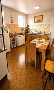 a kitchen with a wooden table and a kitchen with a refrigerator at Casa Completa No Centro Para Famílias e Grupos Até 9 Hospedes Com Garagem in Ouro Preto +61 photos