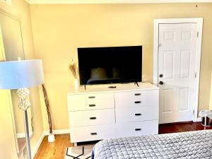 a bedroom with a dresser with a tv on it at The Haven at Mariama House in Upper Marlboro