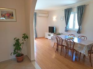 a dining room with a table and chairs and a television at Apartment Marijana in Mlini