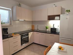 a kitchen with white cabinets and a white refrigerator at Apartment Marijana in Mlini