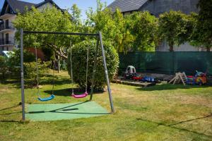 a playground with two swings in a yard at Pokój - Nad Zatoką in Jastarnia