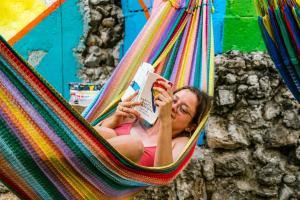 Eine Frau liegt in einer Hängematte und liest ein Buch. in der Unterkunft Garra Charrua in Mérida