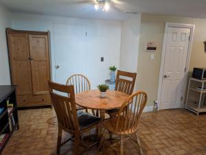 a dining room with a wooden table and chairs at West End Basement Apartment in Toronto