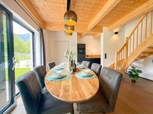 a dining room with a wooden table and leather chairs at Obermöschach 1A in Lake Pressegg