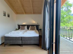 a bedroom with a bed and a balcony at Obermöschach 1A in Lake Pressegg