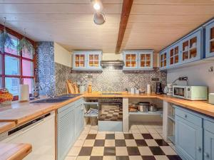 a kitchen with blue cabinets and a checkered floor at Briedel in Briedel