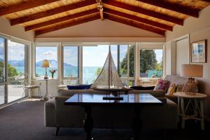 a living room with a sail boat on a coffee table at Expansive Views, Spacious, Large Yard - KK24113 in Kaikoura