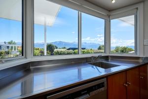a kitchen with a sink and some windows at Expansive Views, Spacious, Large Yard - KK24113 in Kaikoura