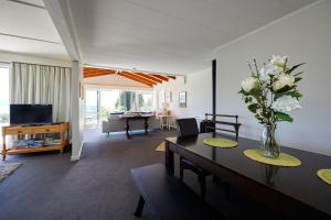a living room with a vase of flowers on a table at Expansive Views, Spacious, Large Yard - KK24113 in Kaikoura +25 photos