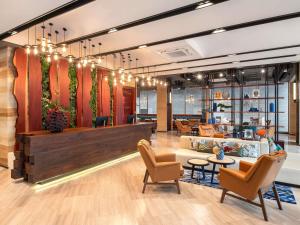 a lobby of a store with chairs and tables at Mercure Bangkok Surawong in Bangkok