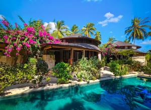 a villa with a swimming pool and flowers at Keong Villas in Nembrala
