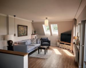 a living room with a couch and a tv at Green Lake House in Petershagen