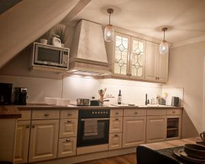 a kitchen with a stove and a microwave at Green Lake House in Petershagen +5 photos