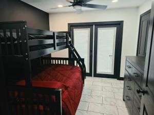 a bedroom with a bunk bed with a red bedspread at Alma House in Corpus Christi