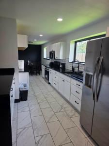 a kitchen with stainless steel appliances and a tile floor at Alma House in Corpus Christi +8 photos